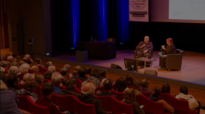 Auditorium des Champs Libres avec du public et sur la scène 2 personnes assises dans des fauteils 