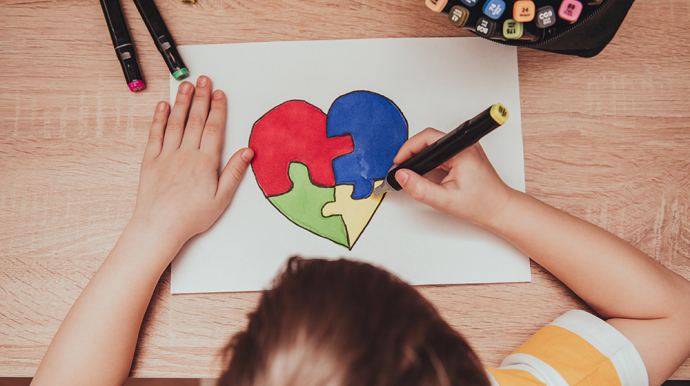 enfant en train de dessiné un coeur, découpé en 3 pièces de puzzle