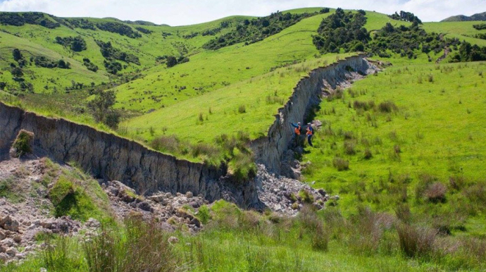 Photo d'un champs verdoyant, avec une fissure en plein milieu